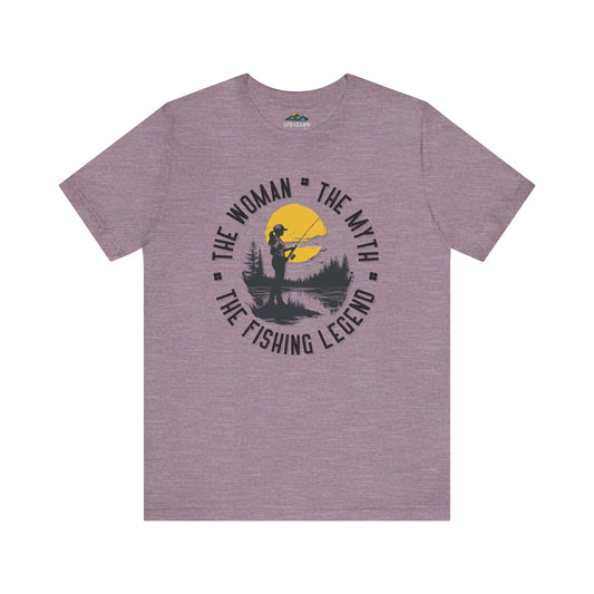 Gray Sunset Catch fishing t-shirt featuring a graphic design of a silhouette of a woman fishing on a boat in a body of water during sunset, along with the text "the woman the myth the fishing legend" above