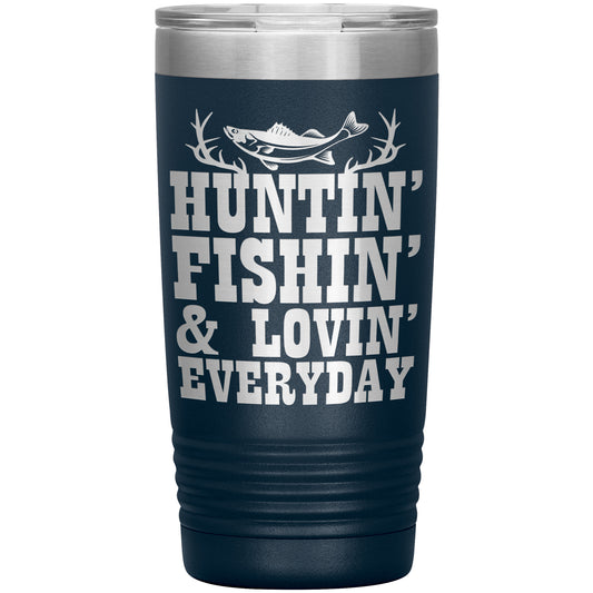 A stainless steel Huntin' and Fishin' travel tumbler with a dark blue gradient finish featuring the phrase "hunting and fishing everyday" in bold, white letters, decorated with antlers and a leaping fish design.