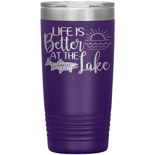 A purple insulated Life is Better at the Lake tumbler with white lettering that says "life is better at the lake," featuring a sun and fish design.
