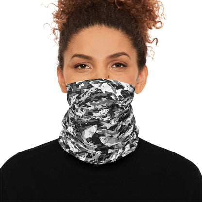 A woman with curly hair wears a Salmon Slayer - Lightweight Neck Gaiter in a fish camo pattern covering her neck and lower face. She is dressed in a black top and looks directly at the
